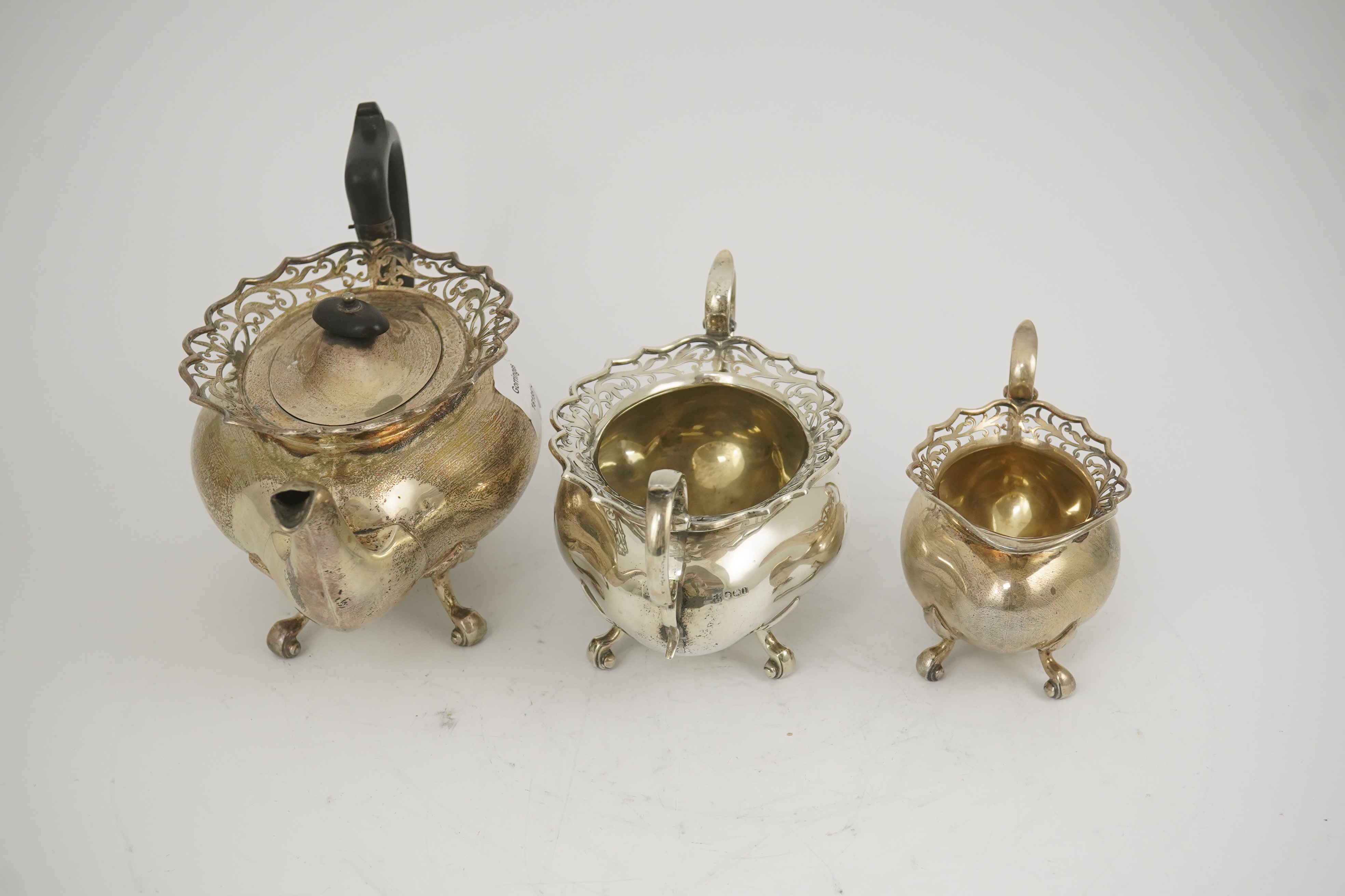 A George V three piece silver circular tea set by James Deakin & Sons